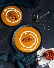 Gesunde Karottensuppe mit knusprigen gerösteten Mandeln, die eine perfekte Kombination aus glatten und knusprigen Texturen bietet.